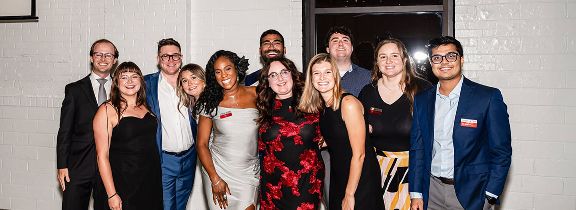 A group of young adults smiling for a photo together